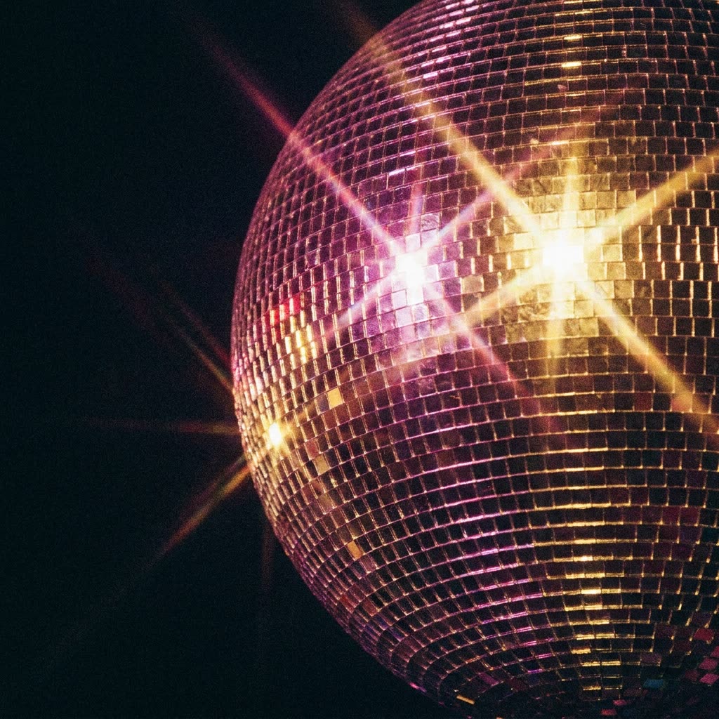 A mirrorball scattering points of light across a dark ceiling.